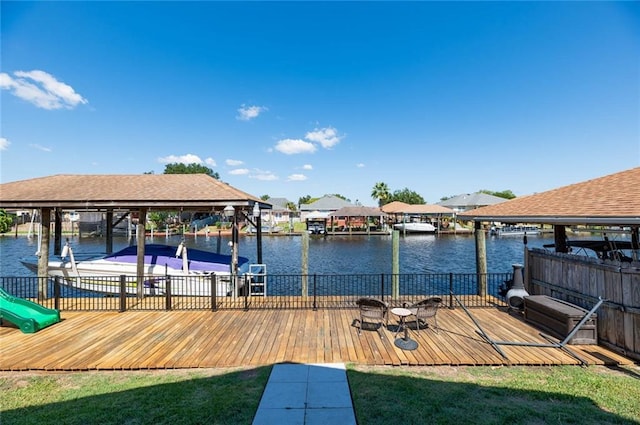 dock area with a lawn and a water view