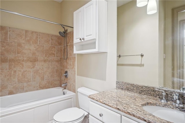 full bathroom with tiled shower / bath, toilet, and vanity