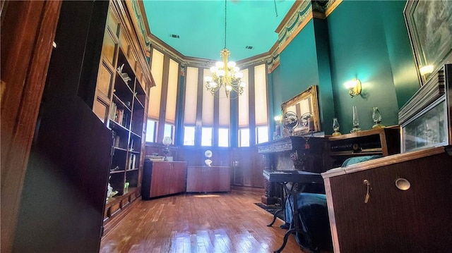 home office with dark wood-type flooring, a chandelier, and a high ceiling