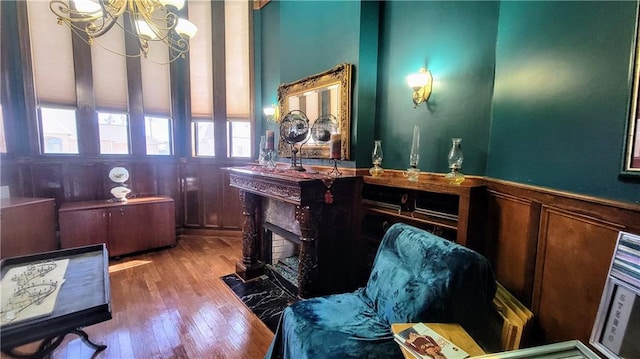 misc room featuring hardwood / wood-style flooring, a notable chandelier, and a fireplace