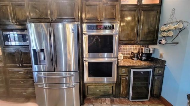 kitchen with appliances with stainless steel finishes, wine cooler, backsplash, dark stone counters, and dark brown cabinets