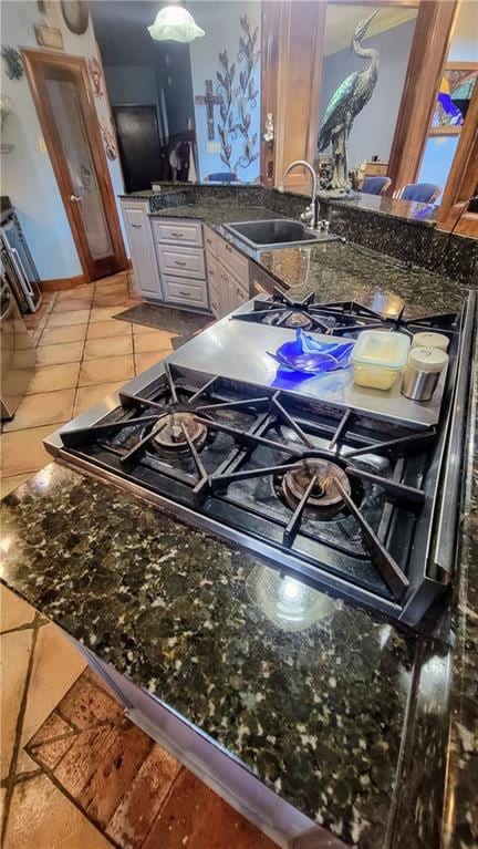 interior space featuring dark stone countertops, sink, tile floors, and white cabinets