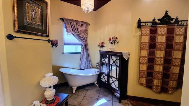 bathroom featuring tile flooring, a notable chandelier, and a washtub