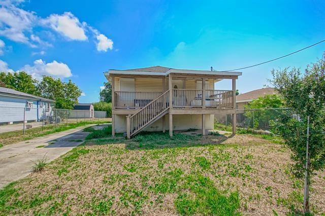 rear view of house featuring a porch and a yard