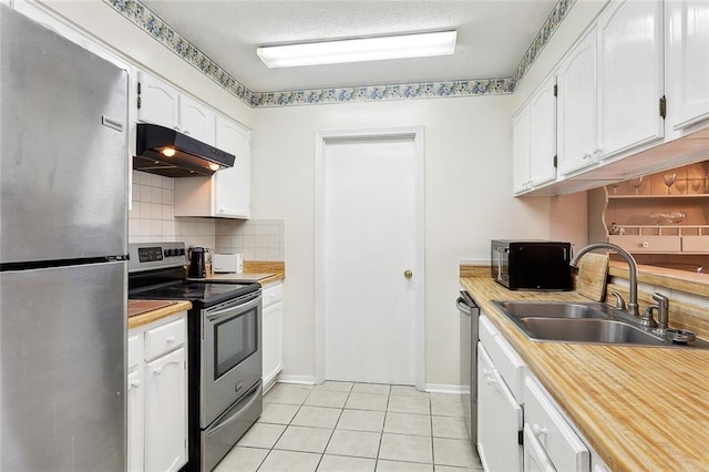 kitchen featuring backsplash, stainless steel appliances, sink, white cabinets, and light tile patterned flooring