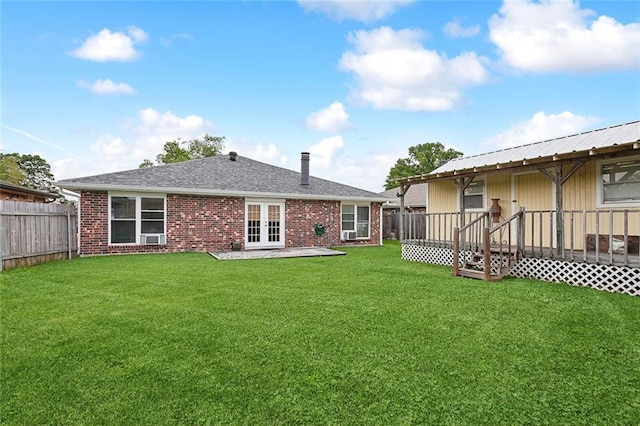 back of house with a lawn and french doors