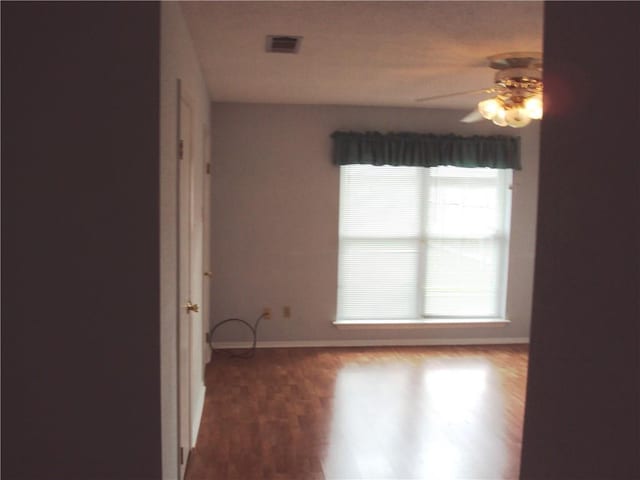 empty room featuring ceiling fan and wood-type flooring