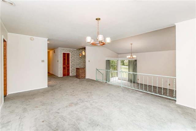 carpeted spare room with lofted ceiling and a chandelier