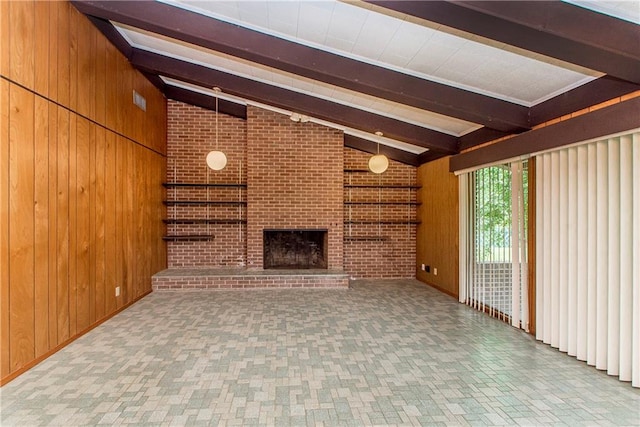 unfurnished living room featuring a brick fireplace, brick wall, vaulted ceiling with beams, wooden walls, and light tile floors