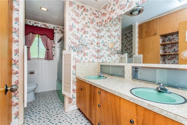 full bathroom with dual bowl vanity, tile walls, tile flooring, combined bath / shower with glass door, and toilet