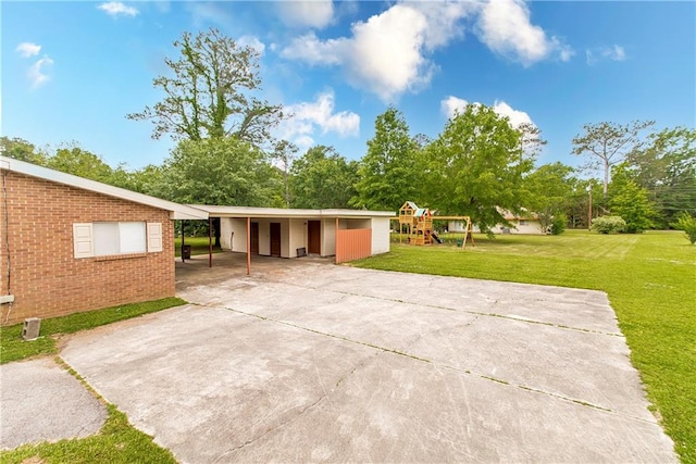 ranch-style home featuring a carport and a front lawn