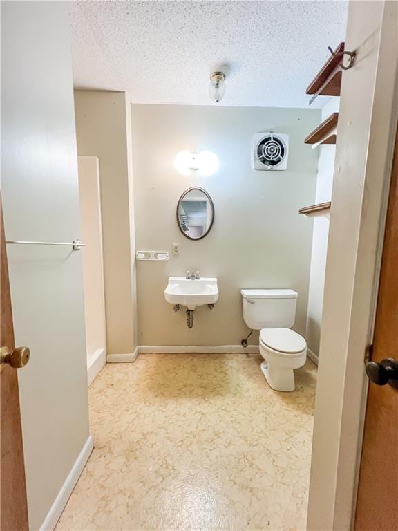 bathroom with sink, toilet, and a textured ceiling