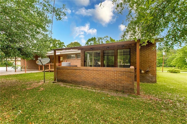 view of side of home featuring central AC, a yard, and a patio area