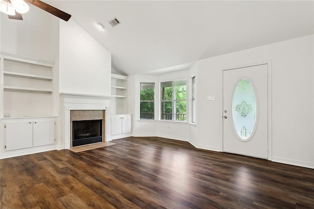 unfurnished living room featuring a tiled fireplace, ceiling fan, dark hardwood / wood-style floors, and vaulted ceiling