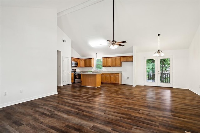 kitchen featuring a wealth of natural light, a kitchen island, decorative light fixtures, and appliances with stainless steel finishes