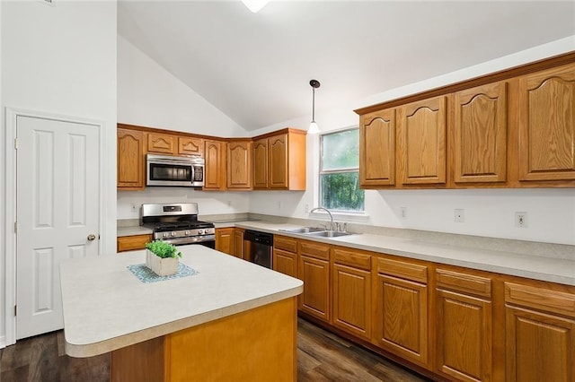 kitchen featuring appliances with stainless steel finishes, dark hardwood / wood-style flooring, sink, decorative light fixtures, and a center island