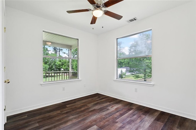 spare room featuring dark hardwood / wood-style flooring, a wealth of natural light, and ceiling fan