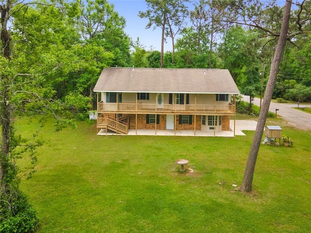 back of property featuring a lawn, a wooden deck, and a patio