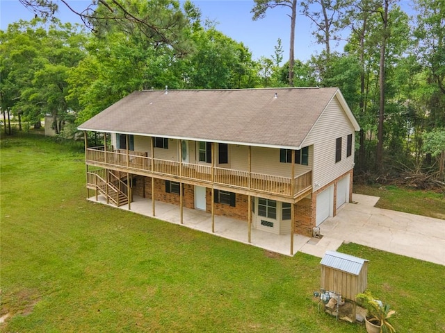 back of property with a patio area, a yard, a wooden deck, and a garage