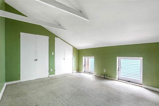 unfurnished bedroom with carpet floors and vaulted ceiling