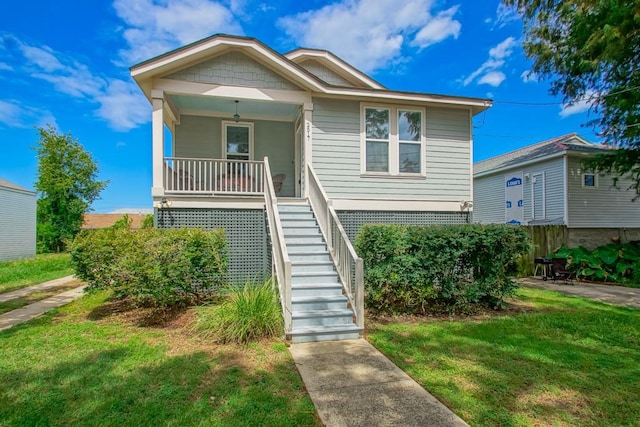 bungalow featuring covered porch and a front yard