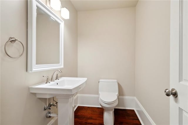 bathroom featuring hardwood / wood-style flooring and toilet