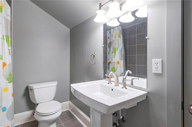 bathroom with sink, vaulted ceiling, tile patterned flooring, toilet, and curtained shower