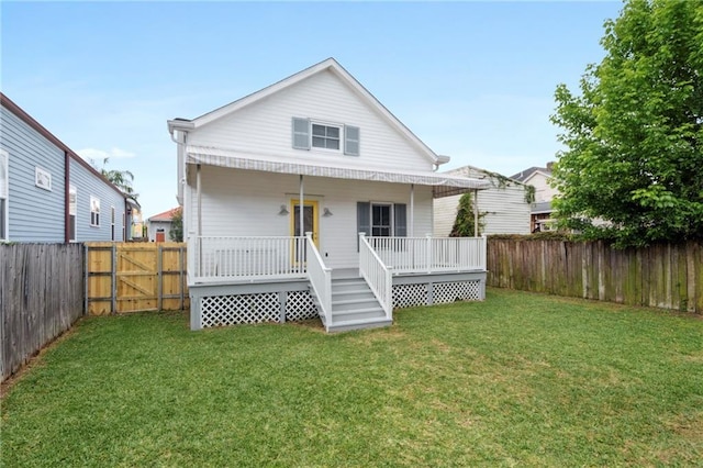 back of property with a yard and covered porch