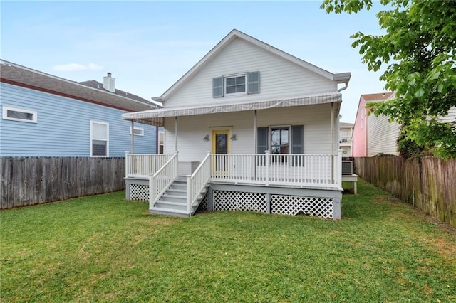 rear view of house with a lawn and a porch