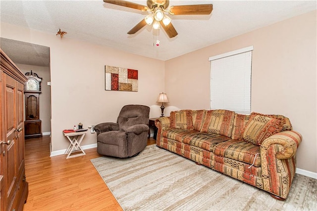 living room with ceiling fan and light wood-type flooring