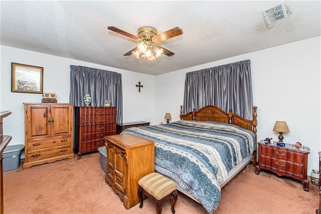 carpeted bedroom with a textured ceiling and ceiling fan