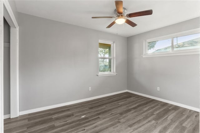 spare room featuring ceiling fan, plenty of natural light, and dark hardwood / wood-style floors