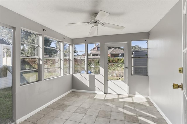 unfurnished sunroom featuring ceiling fan