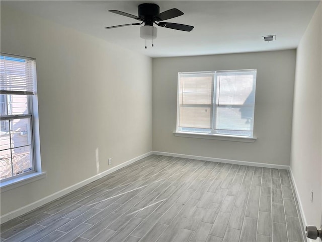 spare room with light hardwood / wood-style floors, ceiling fan, and a wealth of natural light