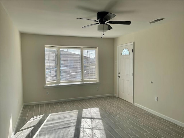 empty room featuring a wealth of natural light, ceiling fan, and hardwood / wood-style floors