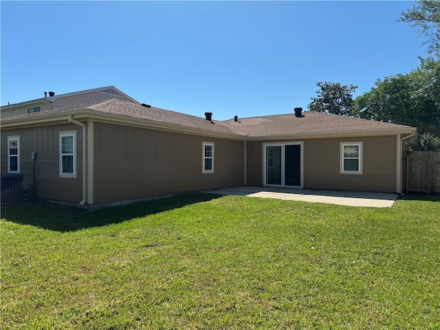 back of property with central AC unit, a lawn, and a patio area