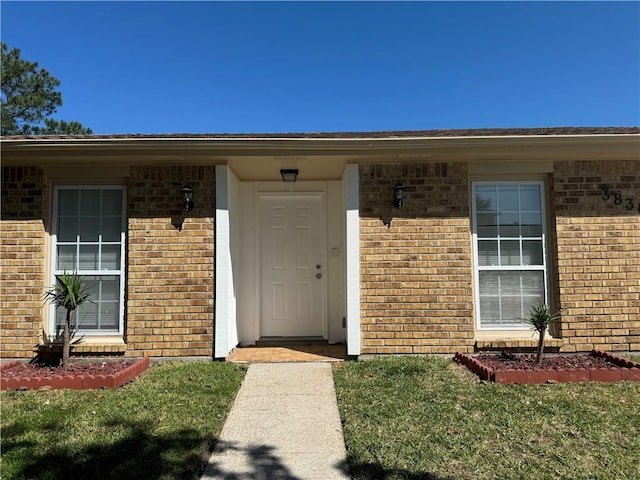 view of exterior entry with a yard