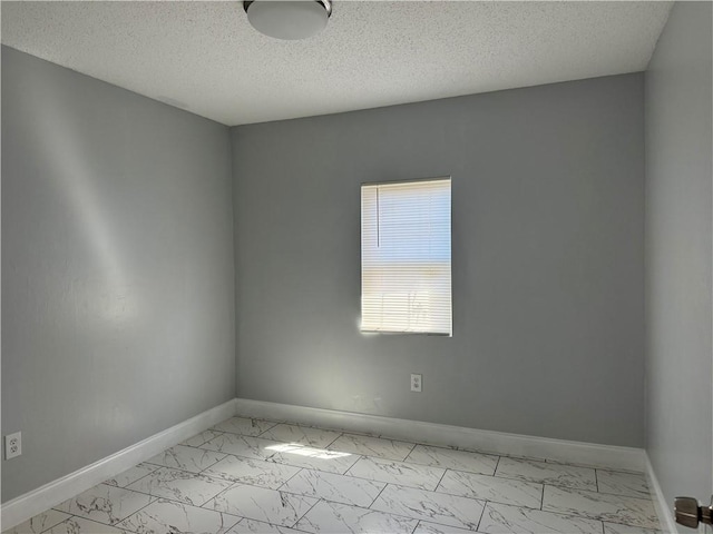 tiled spare room with a textured ceiling