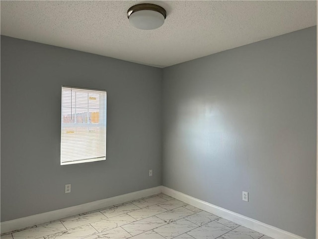 unfurnished room with light tile floors and a textured ceiling