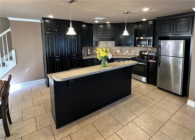 kitchen featuring appliances with stainless steel finishes, tasteful backsplash, pendant lighting, and a center island