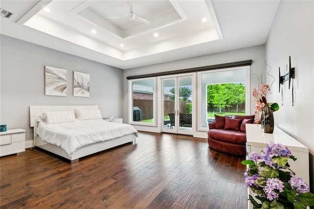 bedroom featuring access to outside, ceiling fan, a tray ceiling, and dark wood-type flooring