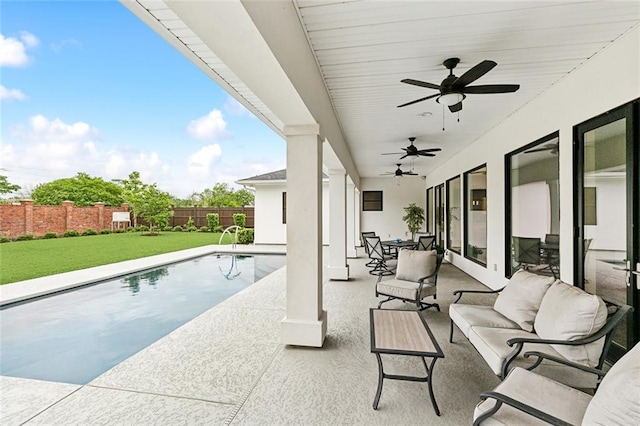 view of pool featuring a patio area, a yard, ceiling fan, and an outdoor hangout area