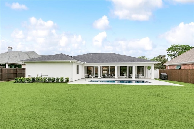 back of property with a patio, a yard, and a fenced in pool