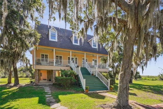 view of front facade featuring covered porch, ceiling fan, and a front yard