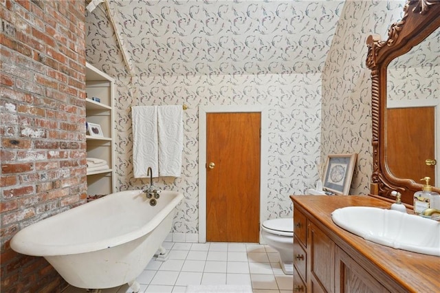 bathroom with vanity with extensive cabinet space, toilet, brick wall, tile flooring, and a tub