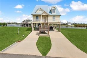 view of front facade featuring a water view and a front lawn