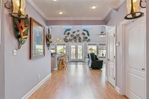 hall featuring french doors, crown molding, and hardwood / wood-style floors