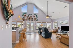 living room with wood-type flooring, high vaulted ceiling, ceiling fan, and french doors