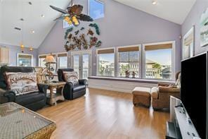 living room with high vaulted ceiling, ceiling fan, and light wood-type flooring