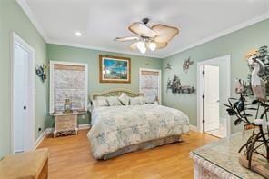 bedroom with hardwood / wood-style floors, ceiling fan, and ornamental molding